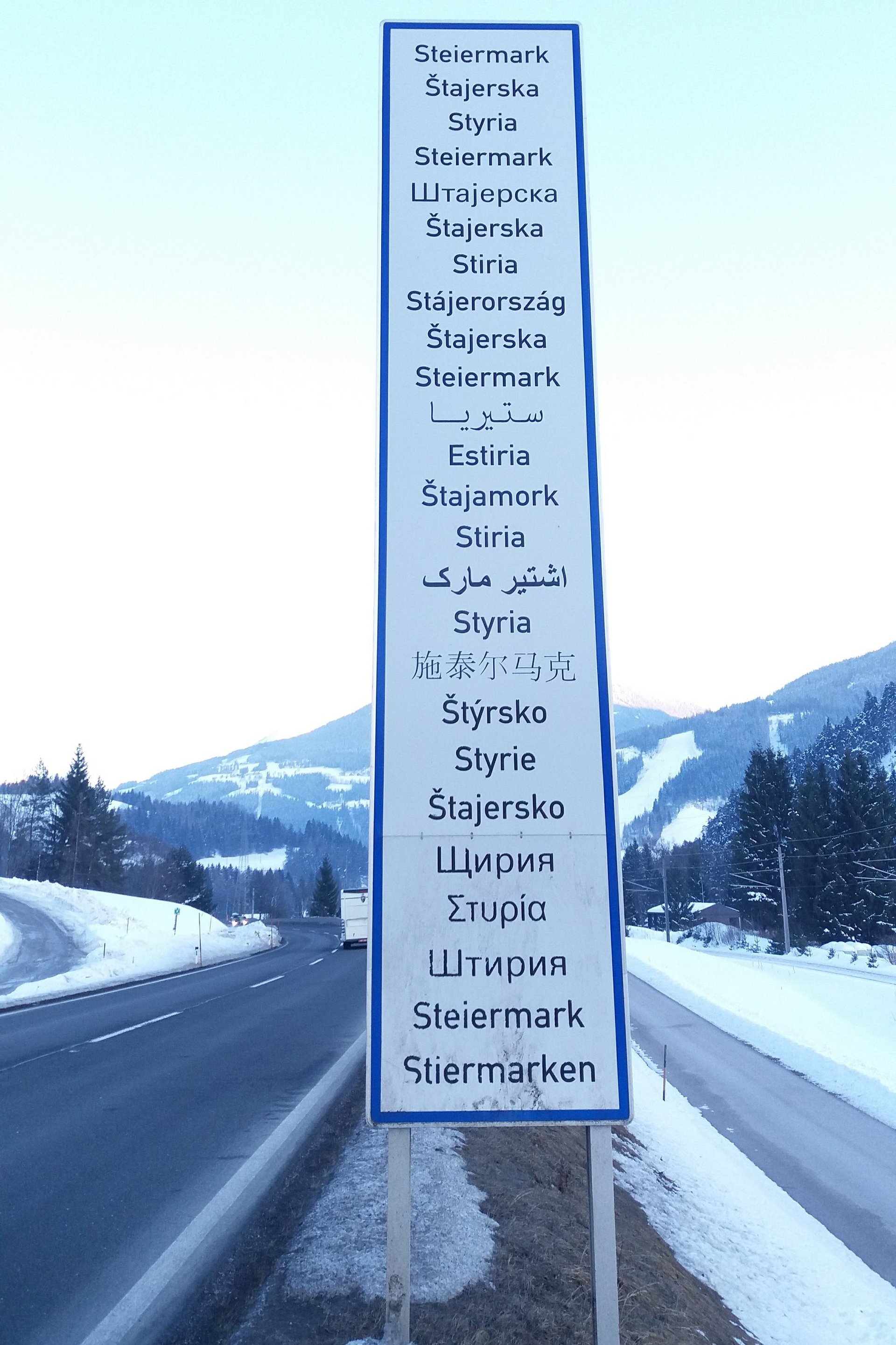 Straßenschild mit Ortsnamen in verschiedenen Landessprachen